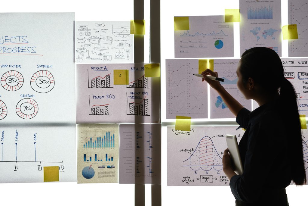 Business woman analyzing charts and graphs handing on the wall